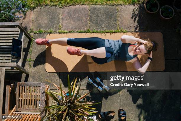 woman exercising in her garden - springtime exercise stock pictures, royalty-free photos & images