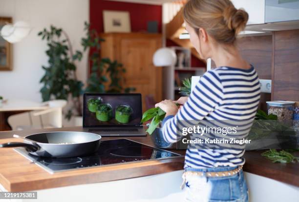 woman cooking with freshly harvested ramson leaves, using computer - ramson stock-fotos und bilder