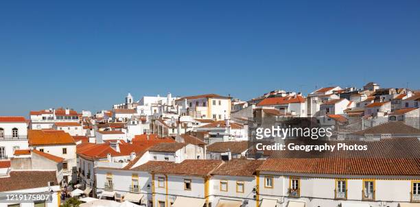 Panoramic style cityscape views over pan tile rooftops and whitewashed buildings in the city center of Evora, Alto Alentejo, Portugal, southern...