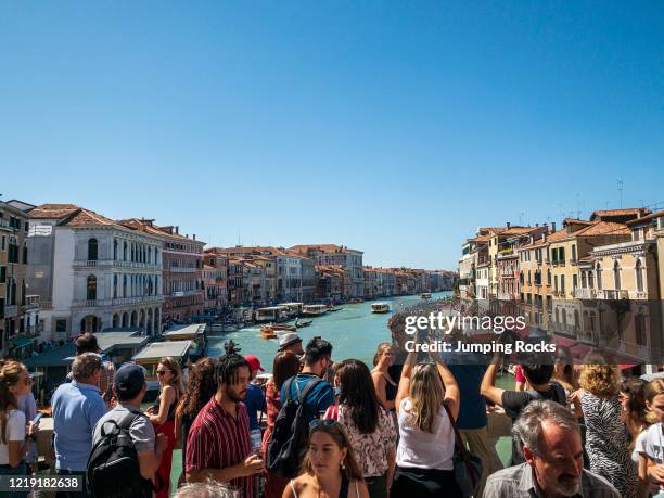 Rialto Bridge overlooking Grand Canal with crowds of tourist, Venice, Italy.