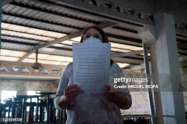 Singer of the Apostol Santiago choir wearing a face mask attends their first rehearsal after the loosening of a national lockdown to stop the spread...