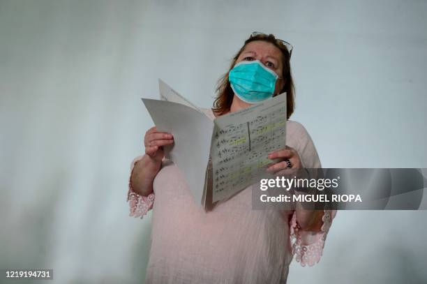 Singer of the Apostol Santiago choir wearing a face mask attends their first rehearsal after the loosening of a national lockdown to stop the spread...