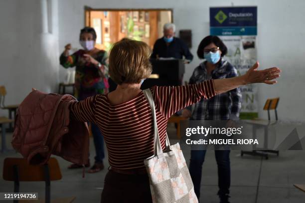 Singers of the Apostol Santiago choir, wearing face masks, greet each other as they arrive to attend the first rehearsal after the loosening of a...