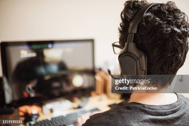 man playing videogames - computer headset stock pictures, royalty-free photos & images