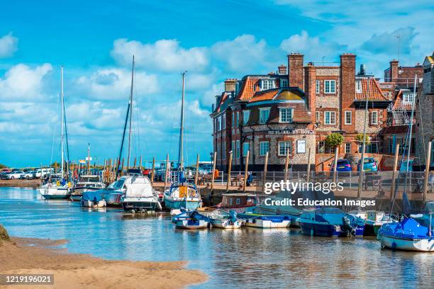 Boats at Blakeney Quay with Blakeney Hotel, North Norfolk coast, England, UK.