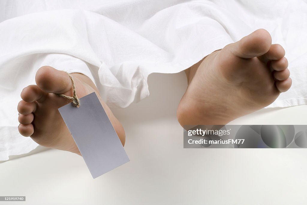 Close-up of feet with hang tag on a dead body in morgue