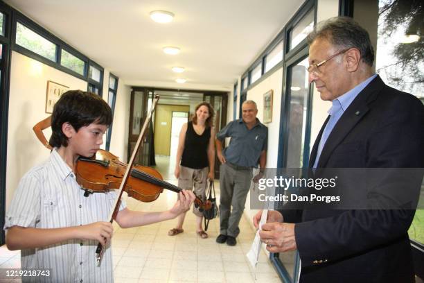 In a hallway at the Max Stern Yezreel Valley College, a student plays violin as Indian-born Chief Conductor and Music Director of the Israel...