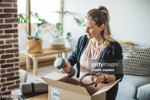 unpacking workout equipment delivery in pandemic situation - sports equipment stock pictures, royalty-free photos & images