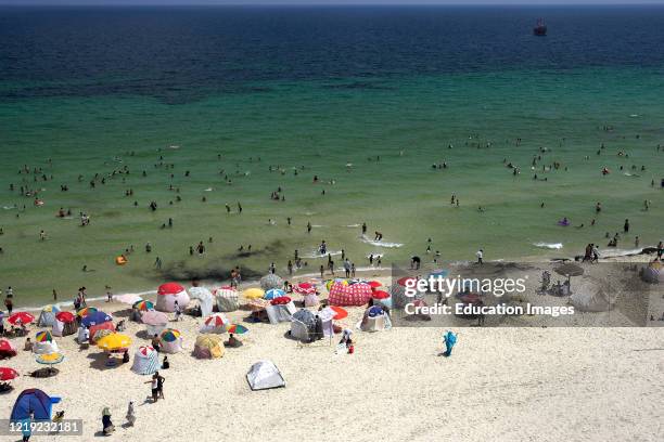 Sunshades and windbreaks dot popular Boujaffar Beach Sousse Tunisia.