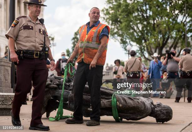 Statue of Christopher Columbus, which was toppled to the ground by protesters, is loaded onto a truck on the grounds of the State Capitol on June 10,...