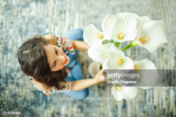 frau arrangieren calle in vase - calla lilies white stock-fotos und bilder