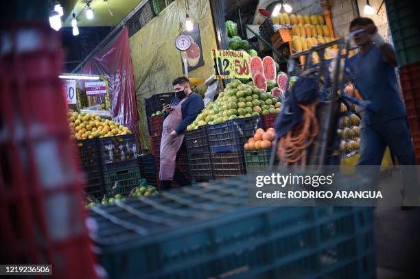 Fruit vendor uses his phone at the Central de Abastos market in Mexico City, on June 10, 2020 during the COVID-19 coronavirus pandemic. - The Central...