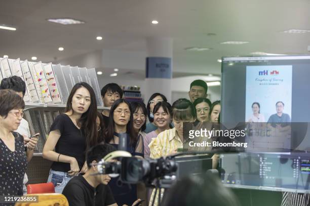 Employees observe from behind camera equipment as their colleagues rehearse hosting a livestream session for the upcoming Canton Fair inside a...