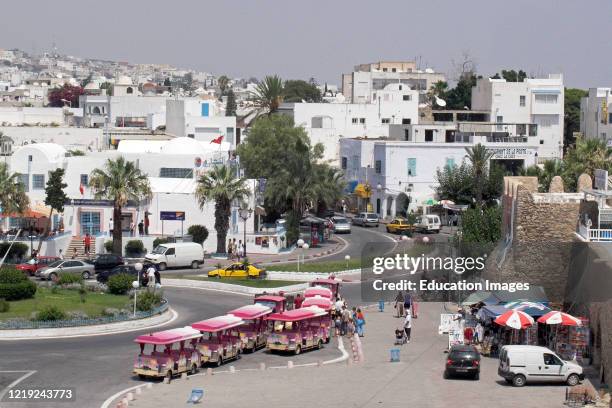 Pink seaside road trolley waits for passengers outside the fort Hammamet resort town Tunisia.