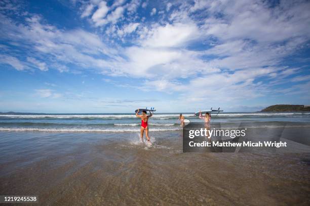 surfers have fun with friends while surfing in the waves. - coffs harbour stock-fotos und bilder