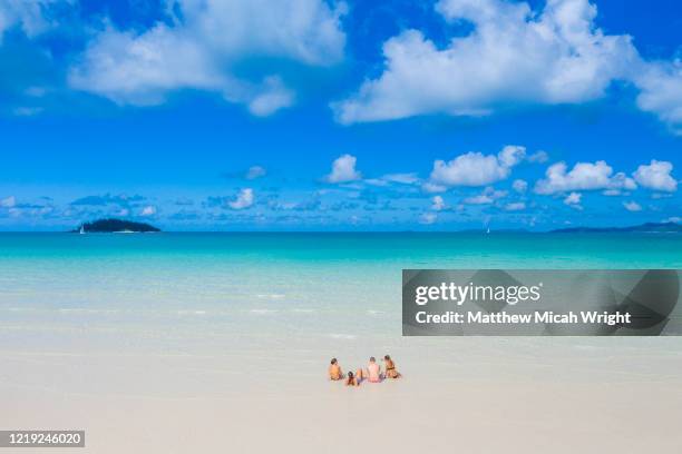 friends sit in the warm clear waters. - whitehaven beach stockfoto's en -beelden