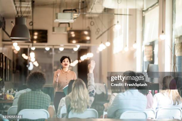 business seminar: businesswoman gives a presentation to a crowd of people - hand wide angle stock pictures, royalty-free photos & images