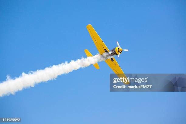old fashioned bright yellow propeller plane in sky - airshow stock pictures, royalty-free photos & images