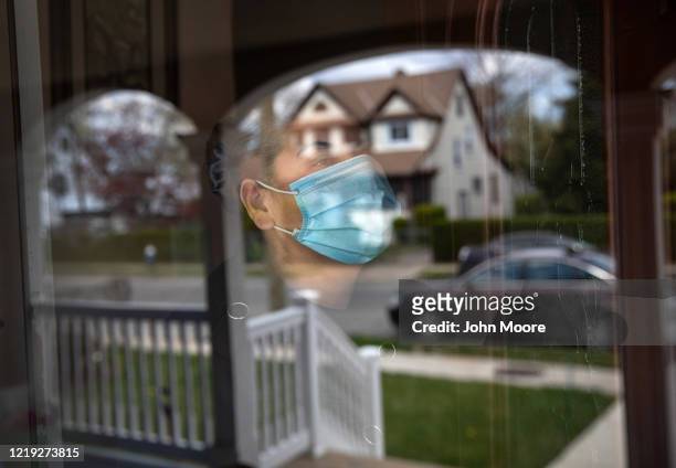 Salvadorian immigrant Ledis, quarantined at home with COVID-19, looks from her front door on April 16, 2020 in Long Island, New York. Ledis has been...