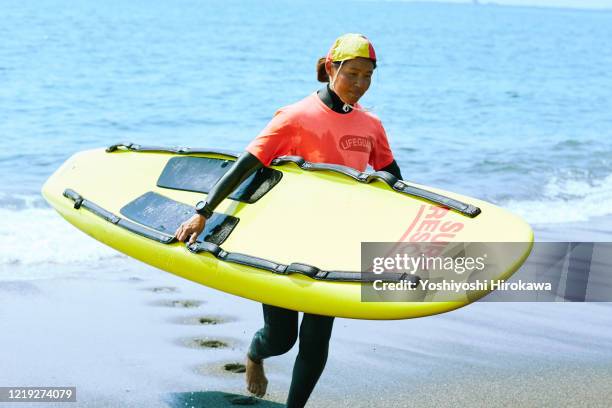 female life saver in forties training rescue board - surf rescue stock pictures, royalty-free photos & images