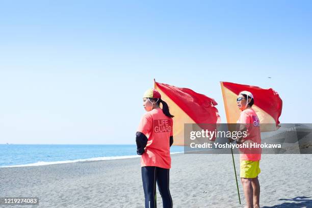lifesaving mentor and college student with flag looking at the sea - doing a favor ストックフォトと画像