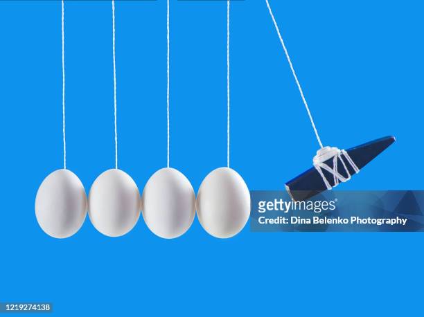 eggs in newton's cradle with a hammer, levitation food photography, minimalist creative scene - newtons cradle stock pictures, royalty-free photos & images