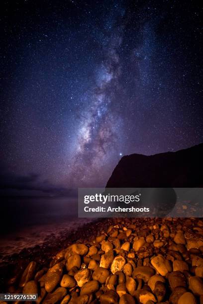 milky way galaxy behind sea bluff and rocky beach - kaupo maui stock pictures, royalty-free photos & images