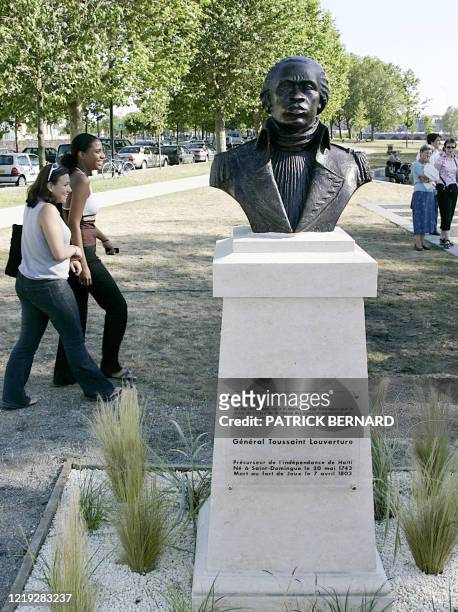 Des personnes passent devant un buste de Toussaint Louverture, père de l'indépendance d'Haïti et précurseur de la lutte contre l'esclavage, le 10...