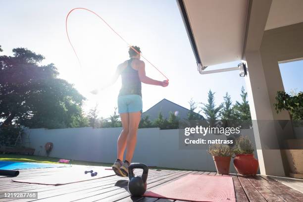 vrouw die geschikt houdt door wat sprongkabel te doen - spring training stockfoto's en -beelden