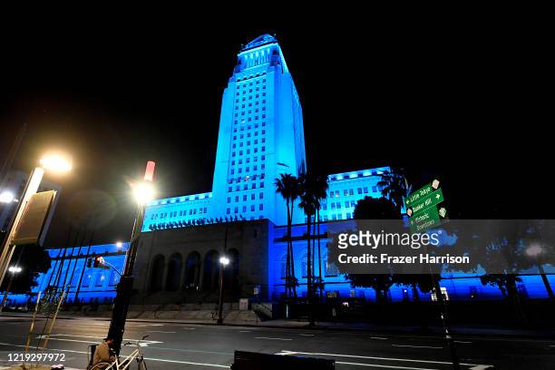 View of Los Angeles City Hall illuminated in blue on April 16, 2020 in Los Angeles, United States. Landmarks and buildings across the nation are...