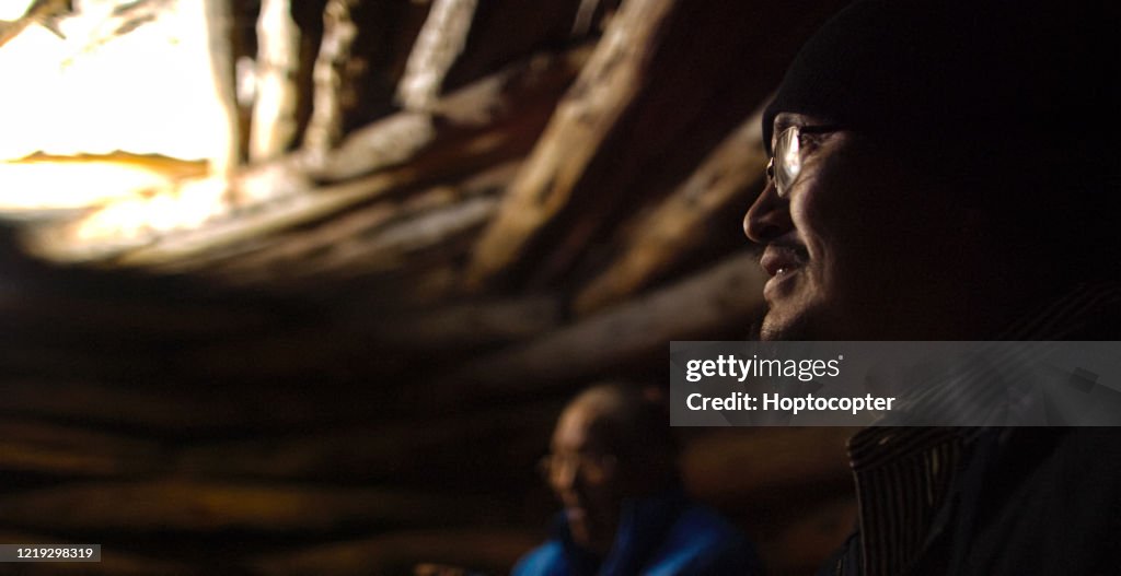 A Native American Man (Navajo) in His Forties Smiles and Talks with Others inside a Hogan (Navajo Hut)