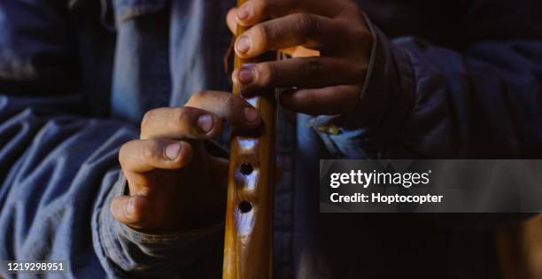 a native american teenaged boy's fingers play a navajo flute in a hogan (navajo hut) - flautist stock pictures, royalty-free photos & images