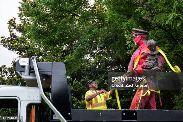 Worker prepares to remove a police memorial statue covered in red paint by protesters on June 11, 2020 in Richmond, Virginia. Protesters also tore...