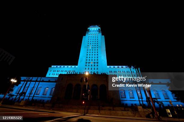 Los Angeles City Hall is lit up in blue on April 16, 2020 in Los Angeles, California, United States. Landmarks and buildings across the nation are...