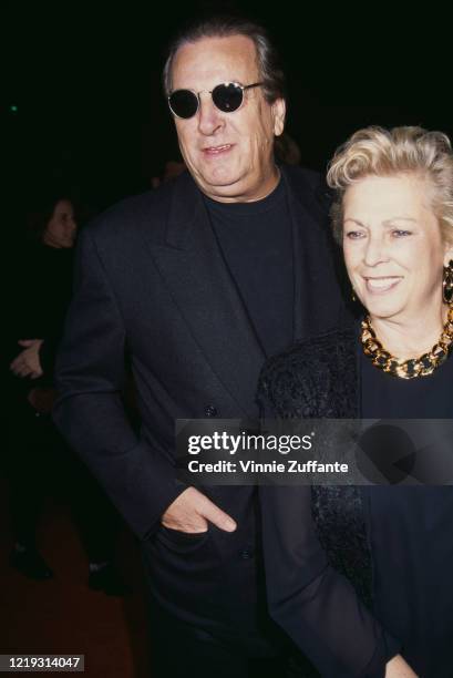 American actor Danny Aiello wearing a black suit with a black crew-neck shirt and sunglasses, with his wife Sandy Cohen at the premiere of 'The...