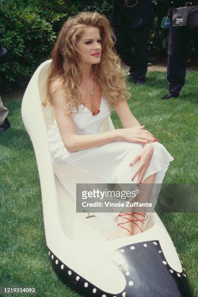American model Rhonda Adams, Playboy magazine's Playmate of the Month for June 1995, poses with an oversized Henri Bendel shoe, as she meets the...