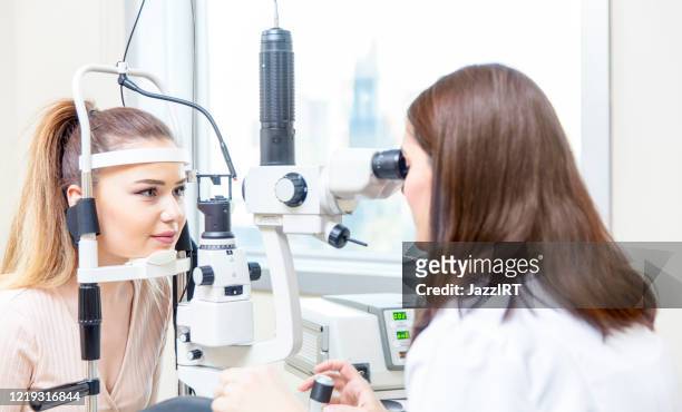 annual eye exam by optometrist - phoropter stock pictures, royalty-free photos & images