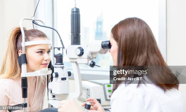 annual eye exam by optometrist - phoropter imagens e fotografias de stock