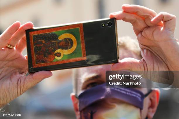Picture of Black Maddona of Czestochowa is seen on a phone of a catholic who attends Corpus Christi procession during the spread of coronavirus....