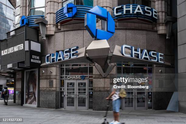 Person on a scooter rides past a JPMorgan Chase & Co. Bank branch in New York, U.S., on Thursday, June 11, 2020. New York streets got a little more...