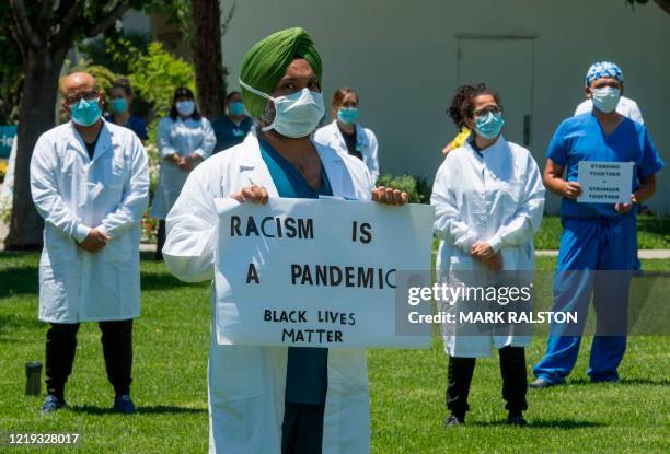 Doctors, nurses and other health care workers participate in a "White Coats for Black Lives" event in solidarity with George Floyd and other black...