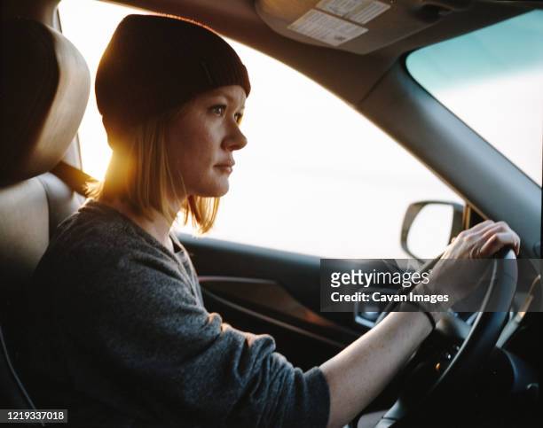 inside view of woman driving in big sur at sunset - big sur stock-fotos und bilder