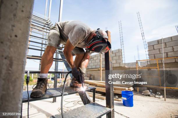 worker welding at construction site - man bending stock pictures, royalty-free photos & images