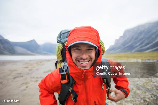 portrait of happy backpacker in remote location. - arctic explorer stock pictures, royalty-free photos & images