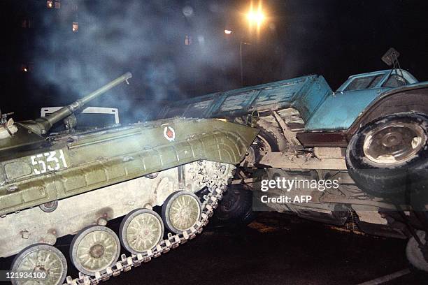 Soviet Army tank pushes over a truck barring the road in the center of Moscow on August 20, 1991 after a coup toppled Soviet President Mikhail...