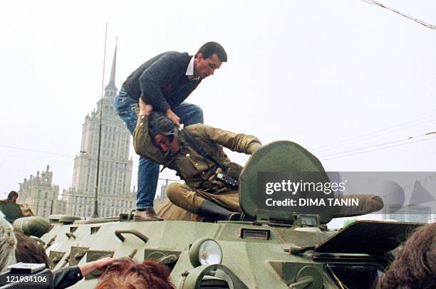 Pro-democracy demonstrator fights with a Soviet soldier on top of a tank parked in front of the Russian Federation building 19 August 1991 after a...