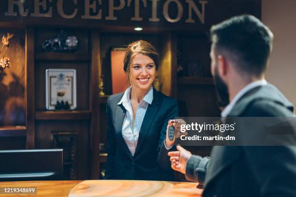 receptionist giving keys to hotel guest - hotel occupation stock pictures, royalty-free photos & images