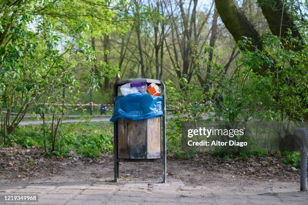 full garbage bin in a park. berlin. germany. - lata de lixo imagens e fotografias de stock