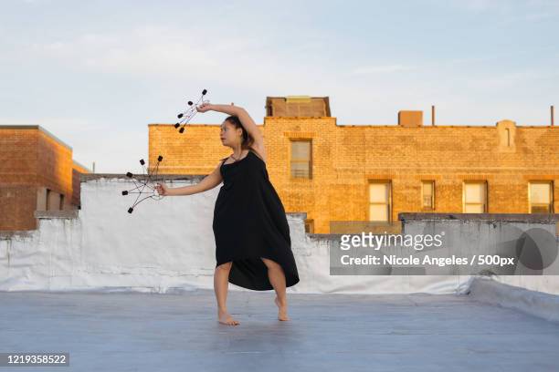 view of woman performing on roof - queens new york city stock pictures, royalty-free photos & images