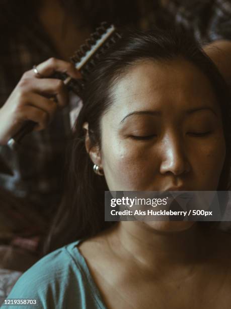 daughter brushing hair of mother - haare kämmen stock-fotos und bilder